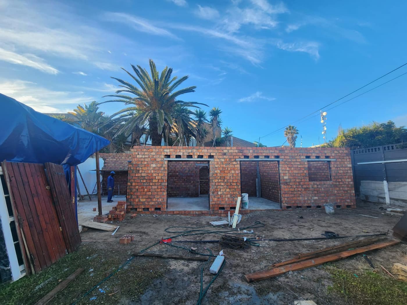 New brick walls complete to lintel height with window and door openings formed