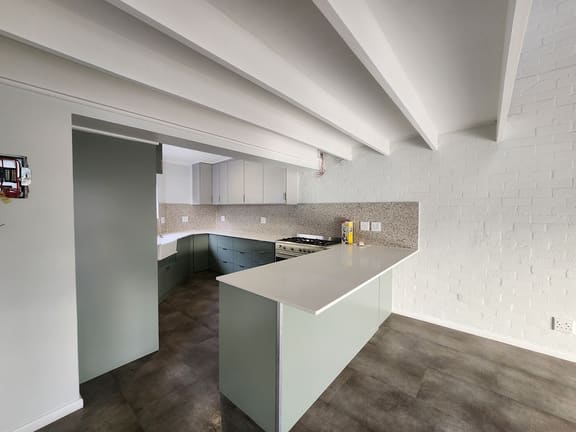 Renovated kitchen with sage cabinetry and terrazzo splashback