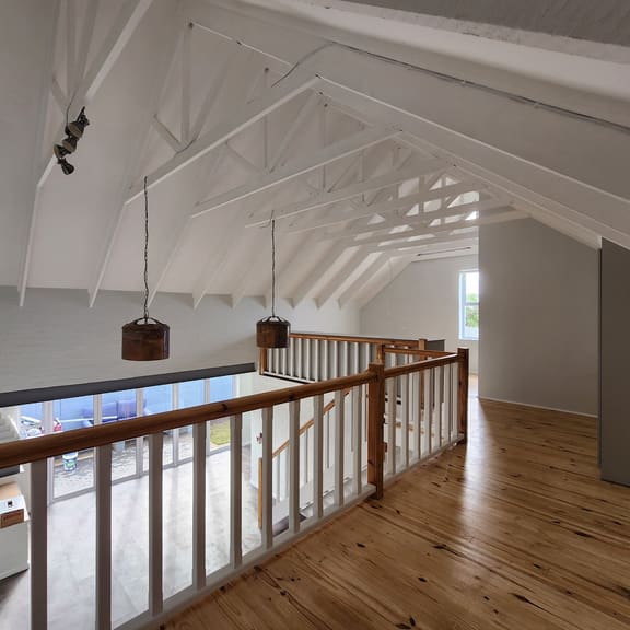 Upper-level loft space with exposed trusses and timber flooring